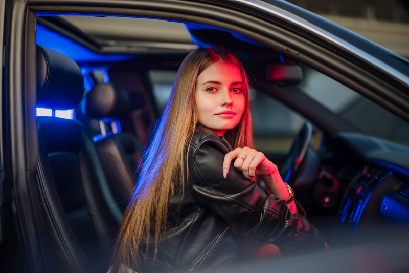 fotografia portretowa modelki w samochodzie oświetlonej lampami LED