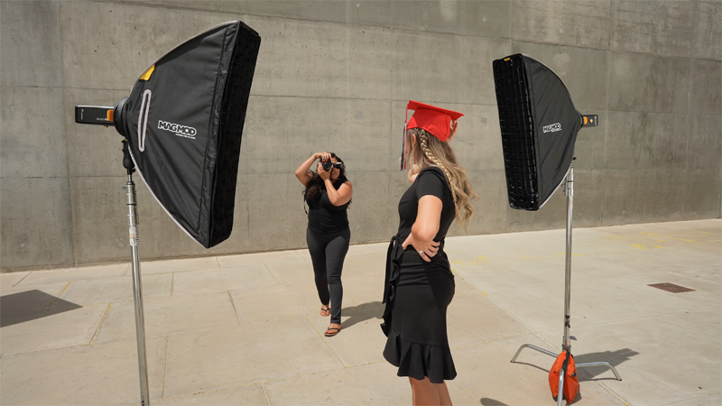 Photographer doing a graduation photoshoot in the city using MagMod MagBox Strip Softboxes